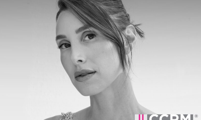 Black and white photo of a woman with hair pulled back, looking at the camera. Text reads: Fertility FM with host Whitney Port, CCRM Fertility, and Dear Media. Pink and white design accents are present.