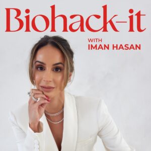 A woman with long brown hair tied back, wearing a white blazer and layered necklaces, poses with her hand near her chin. Red text reads: Biohack-it with Iman Hasan on a white background.