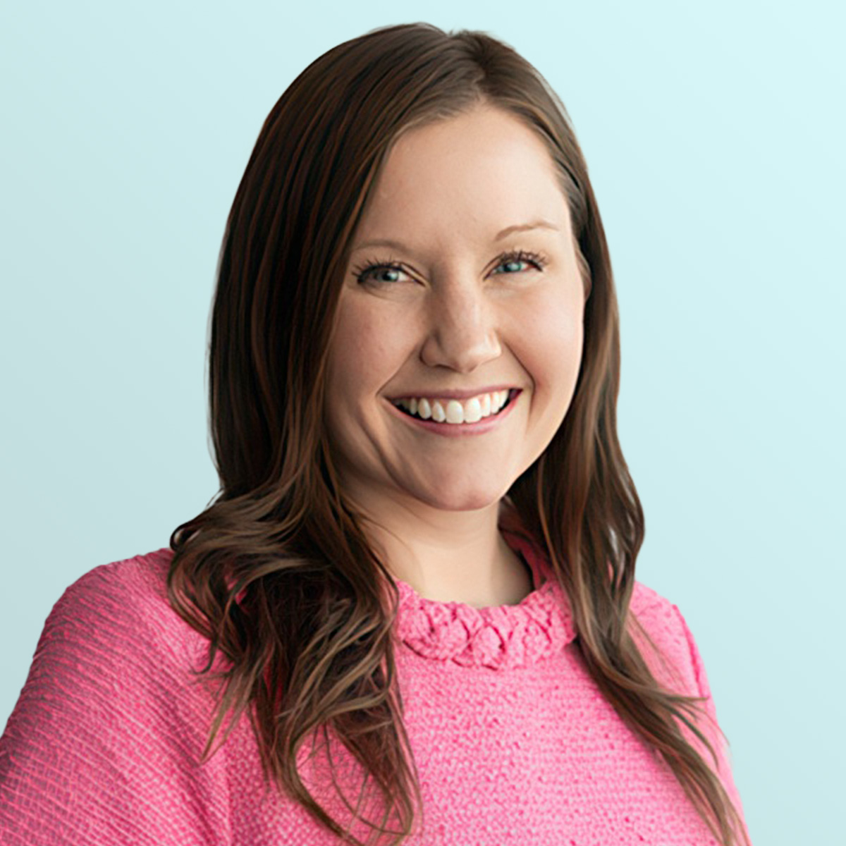 A woman with long brown hair, wearing a bright pink sweater, smiles at the camera against a light blue background.