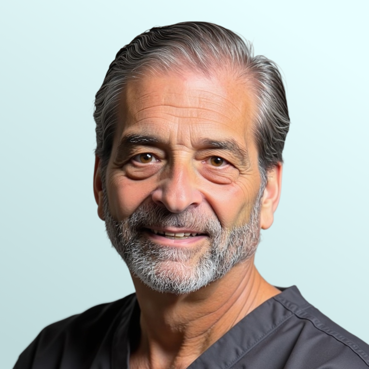 A mature man with gray hair and beard, wearing a navy suit, white shirt, and patterned tie, poses against a light blue background.