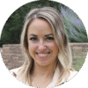 Kelli_Johnson@2x A woman with shoulder-length blonde hair smiles at the camera. She is outdoors, standing in front of a blurred background with trees and a brick wall.