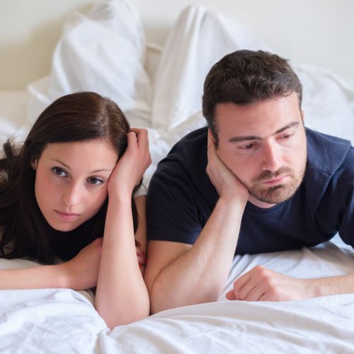 Worried and bored lovers couple after a fight lying in the bed