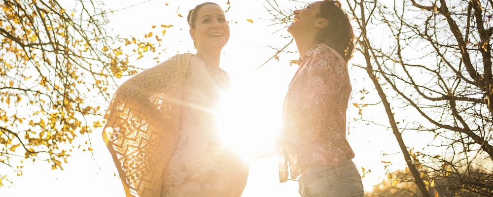 Same sex mothers putting their baby daughter in her cot. The baby is fast asleep.